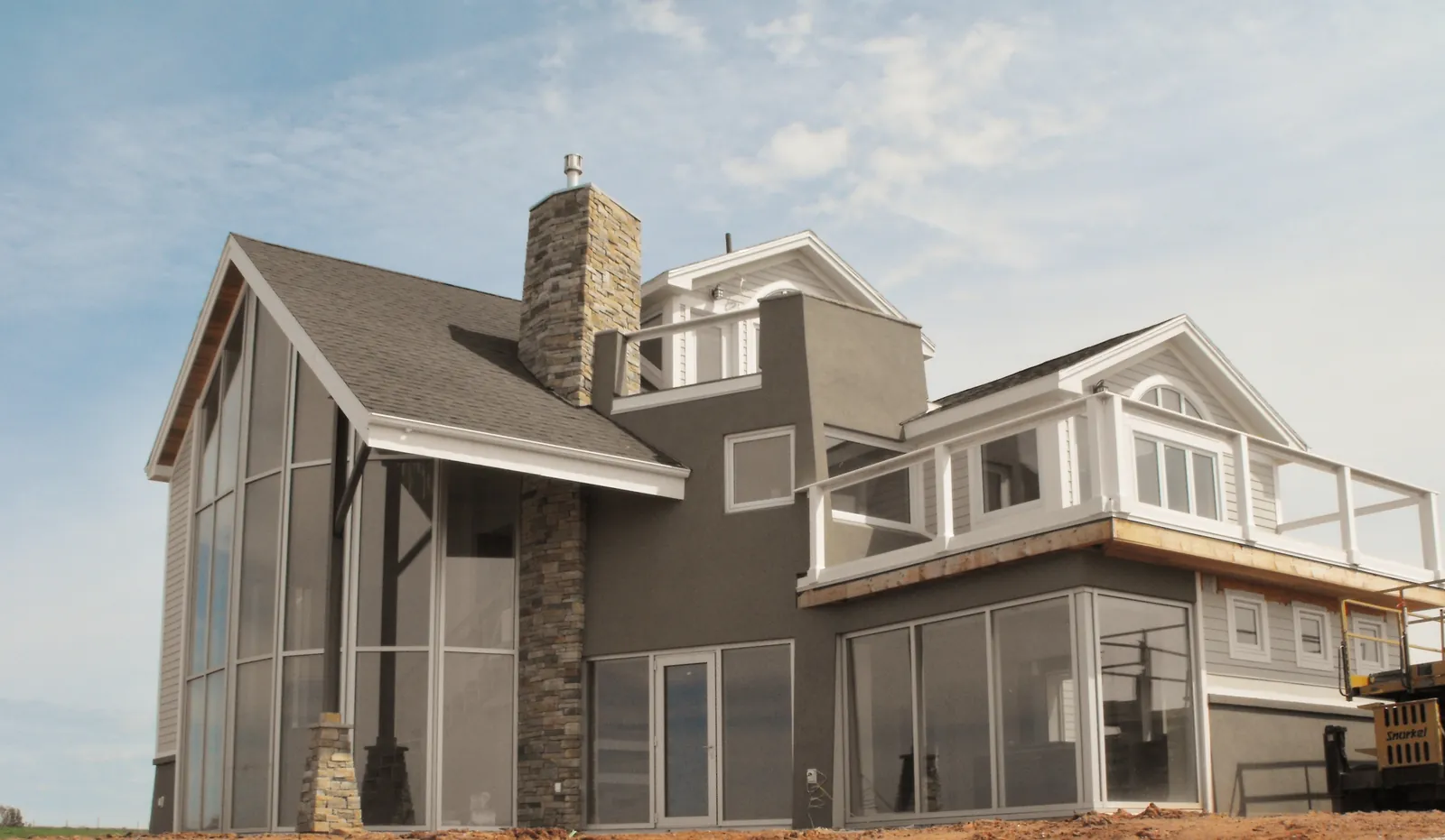 The finished French River home with its stone chimney and glass gable