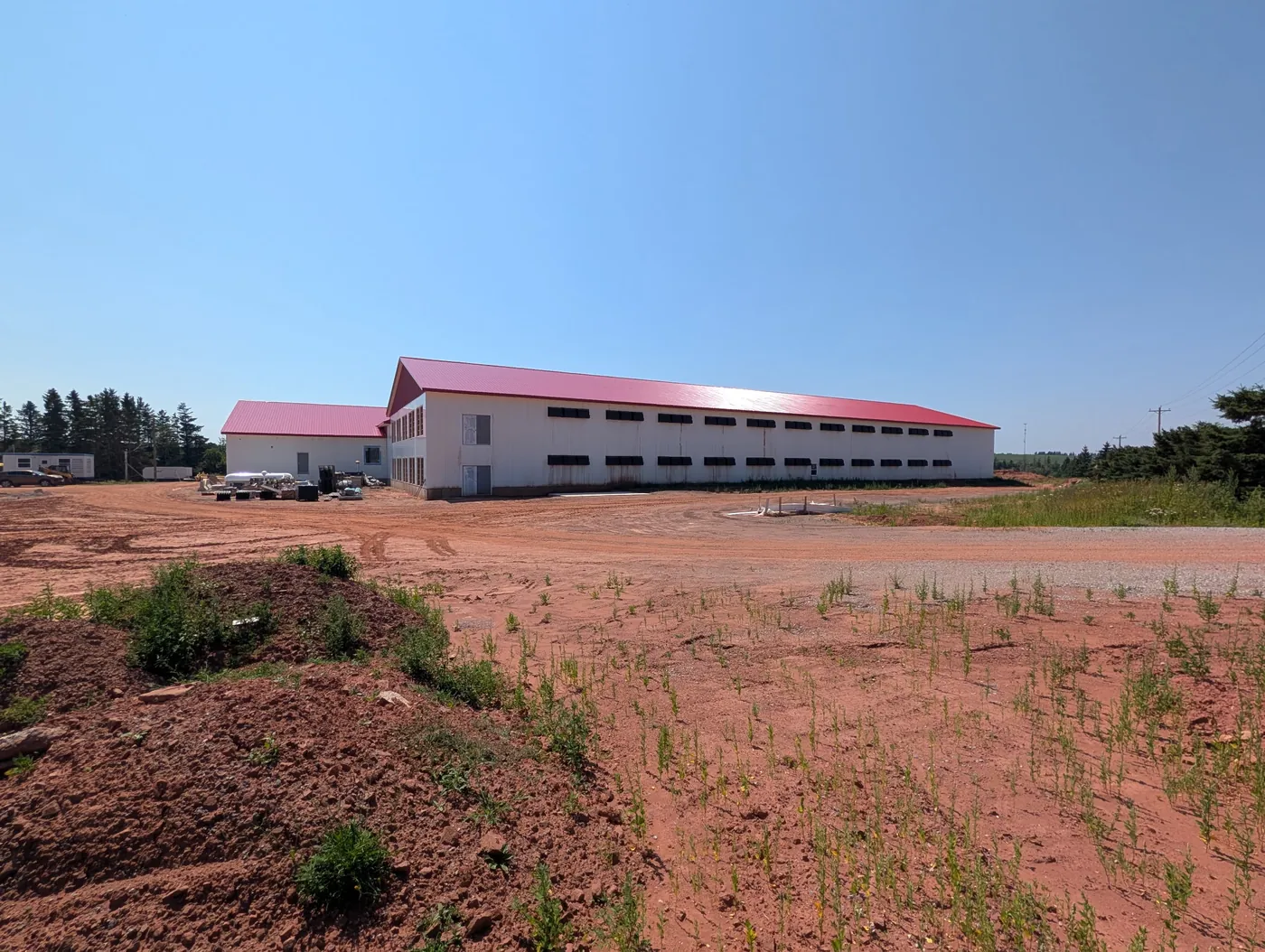 The finished WestCo pullet barn across a red-soil field